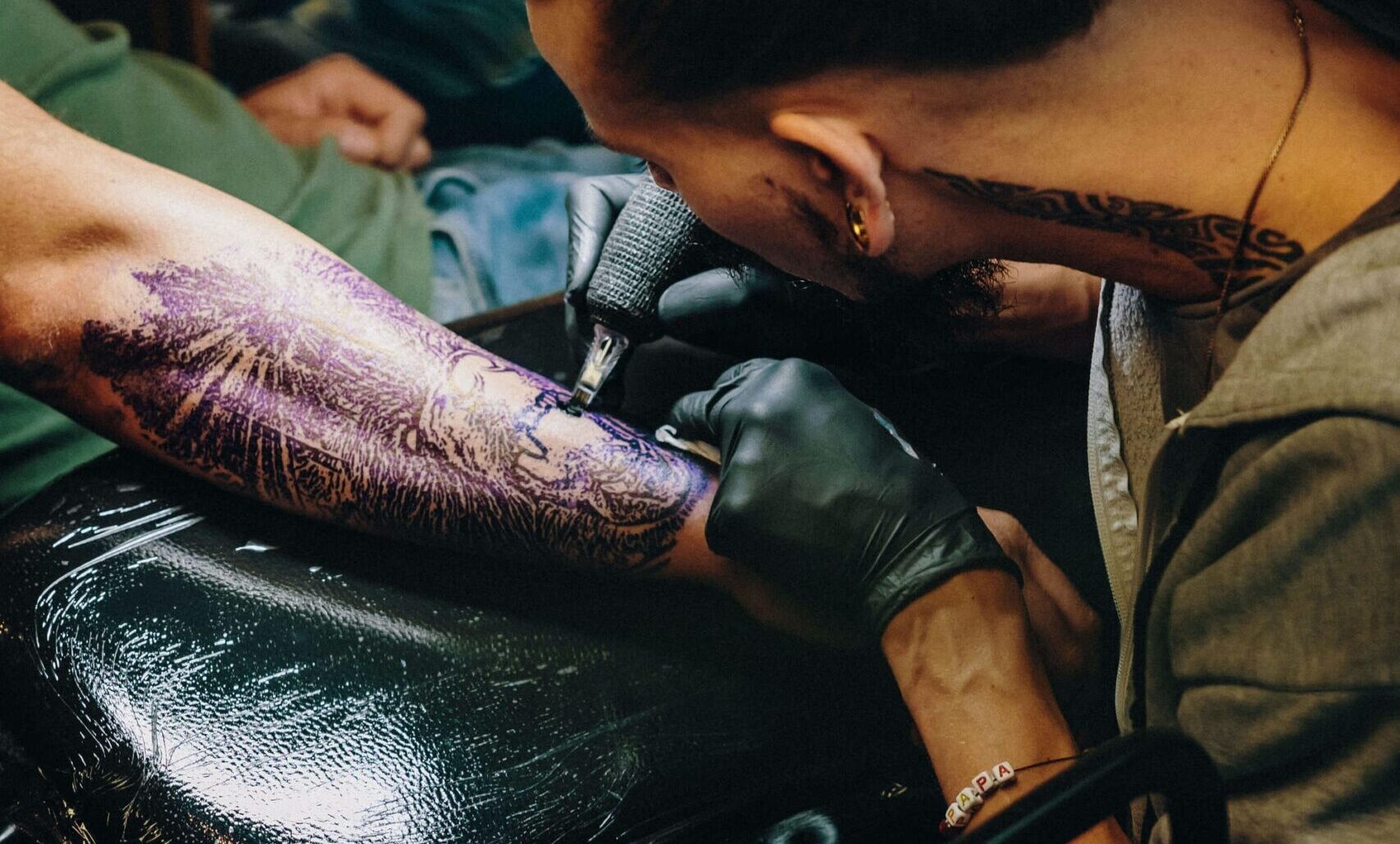 How to become a tattoo artist - A tattoo artist tattooing the underarm of a man.