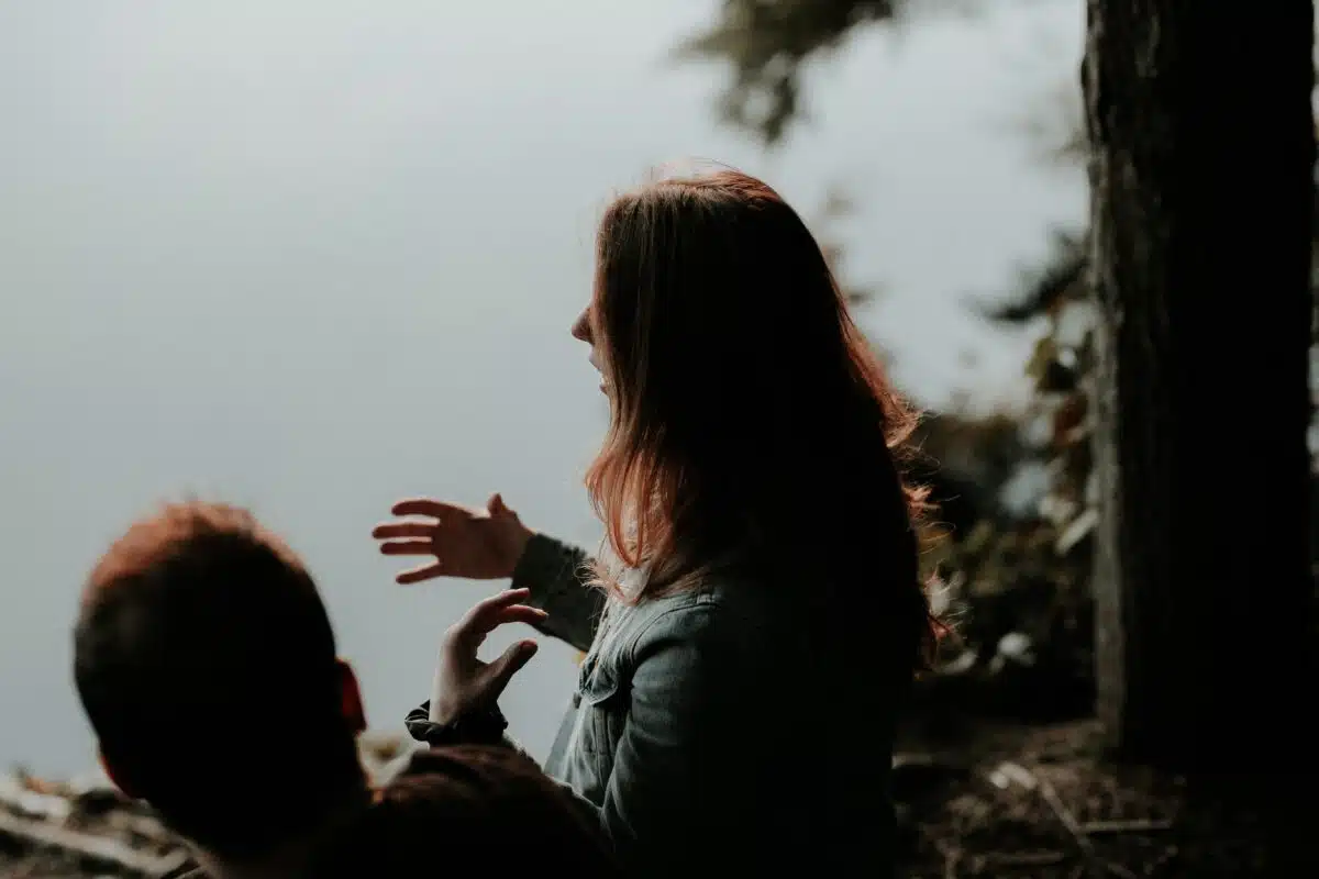 How to become a tattoo artist. Tattoo artist. Woman communicating with a man in front of a lake.