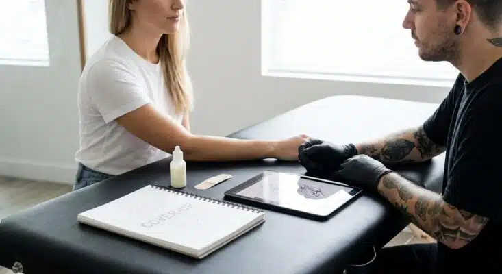 Frau mit einem alten Tattoo, das für eine Tattoo Cover Up Vorbereitung inspiziert wird.