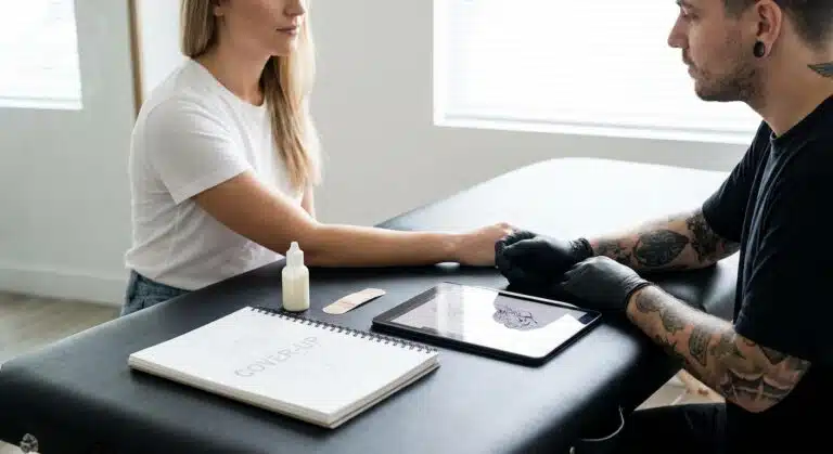 Frau mit einem alten Tattoo, das für eine Tattoo Cover Up Vorbereitung inspiziert wird.